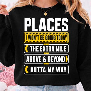 May include: A black crewneck sweatshirt featuring white and yellow graphic text that reads PLACES I WON'T BE GOING TODAY followed by three rectangular signs with arrows pointing to THE EXTRA MILE, ABOVE & BEYOND, and OUTTA MY WAY.