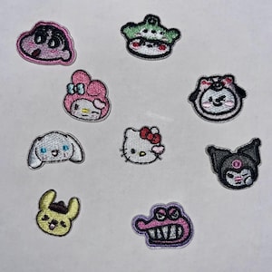 Könnte beinhalten: Eine Sammlung von aufgestickten Aufnähern mit verschiedenen Cartoon-Charakteren. Die Aufnäher zeigen Charaktere wie Hello Kitty und My Melody in leuchtenden Farben. Diese Aufnäher sind wahrscheinlich für Kleidung oder Accessoires gedacht.