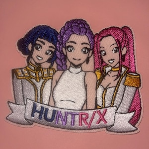 May include: Embroidered patch featuring three anime-style women with different hair colors: blue, purple, and pink. They are wearing white tops and gold-accented jackets. The patch includes the text "HUNTR/X" on a banner.