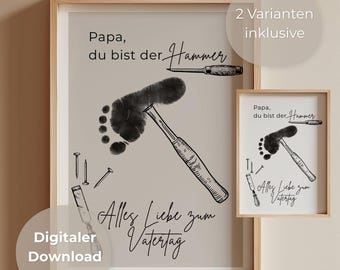 May include: Two framed prints with a light beige background. The larger print features a black footprint forming a hammer, with the text "Papa, du bist der Hammer" and "Alles Liebe zum Vatertag". The smaller print mirrors the design.