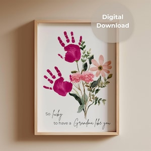 Könnte beinhalten: Gerahmter Druck mit zwei magentafarbenen Handabdrücken und Aquarellblumen. Der Text lautet "so lucky to have a Grandma like you". Ein digitaler Download, ein schönes Geschenk für Großmütter.