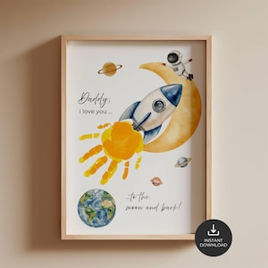 Peut inclure: Une affiche murale encadrée sur le thème de l'espace avec une fusée, un croissant de lune jaune, un astronaute, des planètes et un soleil en forme d'empreinte de main. Le texte indique : Daddy, I love you... to the moon and back! Inclut la Terre.