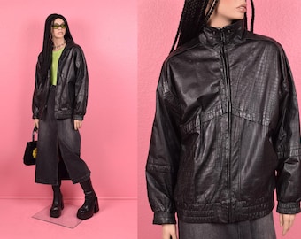 May include: Black leather jacket with a zipper closure and a textured pattern. The jacket has a stand-up collar and long sleeves.