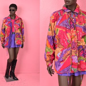 May include: A vintage jacket with a colourful pattern in pink, orange, purple, and green. The jacket has a zip-up front, pockets, and a collar. The mannequin is also wearing a pink top, purple skirt, and black boots.