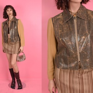 May include: A brown and gold faux leather jacket with a zipper closure and a brown and white striped skirt.