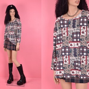 May include: A long-sleeved shirt with a patchwork design featuring a variety of colors and patterns, including red, blue, white, and brown. The shirt has a relaxed fit and a round neckline.