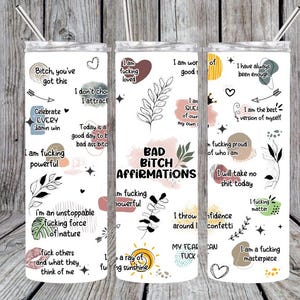 May include: White tumbler with a stainless steel straw, featuring the text "Bad Bitch Affirmations" and various positive affirmations in black and pink. The design includes floral and heart illustrations.