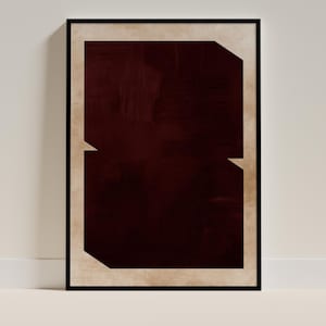 May include: Abstract art print in a black frame. The artwork features a deep burgundy rectangular shape with a lighter beige border. The burgundy shape has a textured, brushstroke appearance. The design includes two angular cutouts.