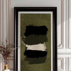 May include: Abstract art print in a black frame. The artwork features horizontal brushstrokes in black, olive green, and white against an olive green background. A white vase with gold accents and dried flowers sits to the left.