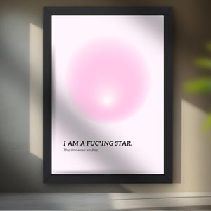 May include: Framed art print with a black border. The print features a soft pink, circular design at the top and the text "I AM A F*C*ING STAR. The Universe said so." in black font at the bottom.
