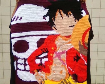 Può includere: Coperta all'uncinetto fatta a mano con un colorato design di personaggi anime. La coperta presenta un motivo a teschio e ossa incrociate in bianco e bordeaux, con un ritratto di un personaggio nei toni dell'arancione, rosso e beige. Bordo rosso.