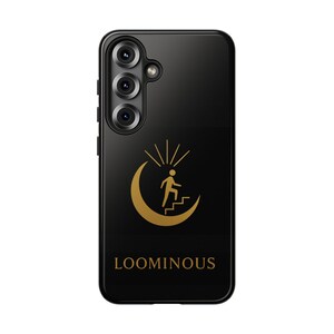 May include: Black phone case with a gold design of a person climbing stairs on a crescent moon, with sun rays above. The word "LOOMINOUS" is printed below. The phone case has three camera lenses.
