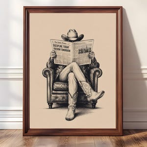 Puede incluir: Impresión artística enmarcada en blanco y negro de un vaquero leyendo un periódico en un sillón de cuero. El titular del periódico dice "DISCIPLINE TODAY FREEDOM TOMORROW". El marco es de madera marrón.