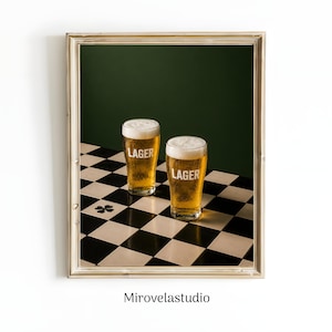 Könnte beinhalten: Ein gerahmter Wandkunstdruck mit zwei Gläsern goldenem Lagerbier mit weißer Schaumkrone, die jeweils mit dem Wort LAGER in weißer Schrift versehen sind. Die Gläser stehen auf einer schwarz-weiß karierten Fläche mit einem kleinen Kleeblatt.