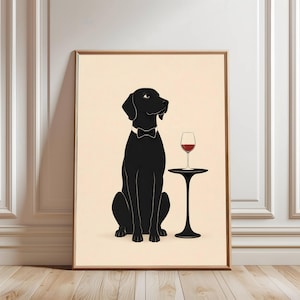 May include: A framed art print featuring a black dog wearing a bow tie, seated next to a small black table with a glass of red wine. The dog is depicted in a minimalist style against a cream background.