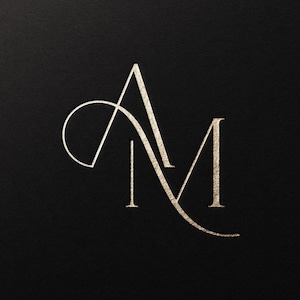 May include: Elegant gold-colored monogram logo featuring the intertwined letters "A" and "M" on a black background. The design has a classic, sophisticated style, suitable for branding or personal use.