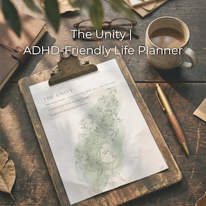 Op de afbeelding: Een houten klembord met een bedrukte pagina met de tekst "The Unity | ADHD-Friendly Life Planner". De pagina bevat een lijntekening van een vrouw met vloeiend haar en bloemmotieven. Een pen en een koffiemok liggen ook op het houten oppervlak.