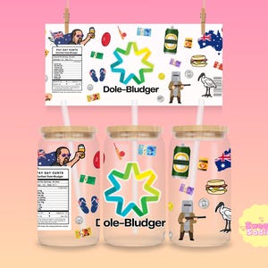 May include: Three glass tumblers with bamboo lids and straws, each featuring a unique design. The designs include an Australian flag, a cartoon man holding a beer, and the text "Dole-Bludger". The tumblers are decorated with various Australian-themed stickers.