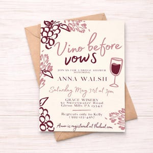 May include: Bridal shower invitation with the text "Vino before vows" in a handwritten style. The invitation features illustrations of grapes and a wine glass in shades of burgundy and pink. The invitation is on a cream background with a brown envelope.