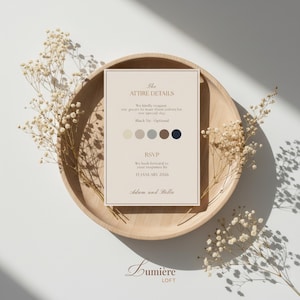 May include: A wedding invitation with "The Attire Details" printed on a cream-colored card. The card includes a color palette and RSVP information. The invitation is placed on a wooden tray and decorated with dried flowers.