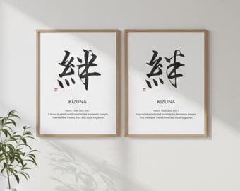 May include: Two framed art prints with Japanese calligraphy. Each print has a large black character, the word "KIZUNA" below, and a short definition. The frames are light brown, and the background is white.