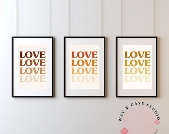 Puede incluir: Tres impresiones artísticas enmarcadas con la palabra "LOVE" apilada verticalmente en tonos cálidos y terrosos. Las impresiones están en marcos negros y cuelgan de una pared blanca. La esquina inferior derecha presenta un logotipo con el texto "WAY & DAYS STUDIO TOKYO, JAPAN."