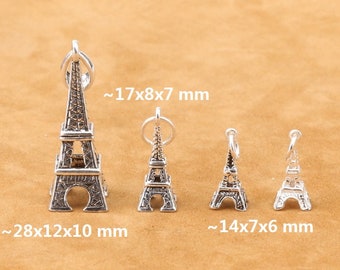 May include: Four silver Eiffel Tower charms of varying sizes. The largest charm measures approximately 28x12x10 mm, the next largest measures approximately 17x8x7 mm, and the two smallest charms measure approximately 14x7x6 mm.