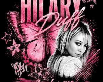 May include: A black graphic print featuring a portrait of Hilary Duff, the text HILARY DUFF, and THE LUCKY ME TOUR. The design includes a large pink butterfly, several pink stars, a signature, and pink halftone dot patterns on a black background.