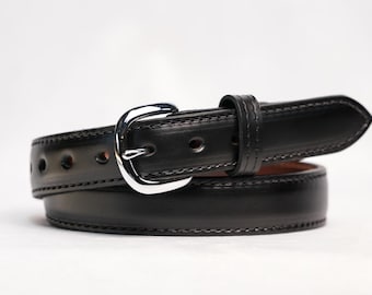 May include: A black leather belt featuring a polished silver-tone metal buckle and a matching leather keeper loop. The belt has visible tonal stitching along the edges and a series of punched holes for adjustment, coiled into a circular shape.