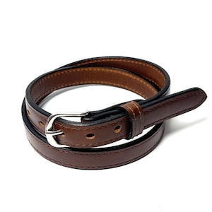 Angled view of brown cowhide raised center belt with dark finished edges