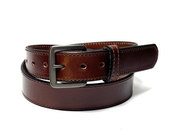 May include: A dark brown leather belt featuring a smooth finish, tonal stitching along the edges, and a rectangular matte grey metal buckle. The belt includes a series of circular adjustment holes and a matching leather keeper loop for securing the end.