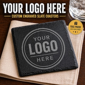 May include: Square black slate coaster with engraved text: "YOUR LOGO HERE". The coaster is on a beige cloth napkin. The text "CUSTOM ENGRAVED SLATE COASTERS" is above the coaster. A glass of water is in the background. A gold sticker says "FREE PROOF WITH EVERY ORDER".