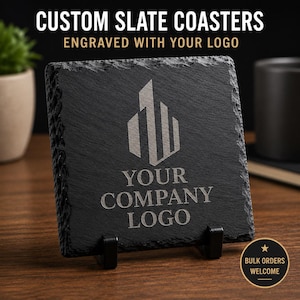 May include: A square black slate coaster with rough, natural edges, featuring an engraved geometric logo and the text "YOUR COMPANY LOGO" in the center. The coaster is displayed upright on a small black stand, showcasing its textured surface.