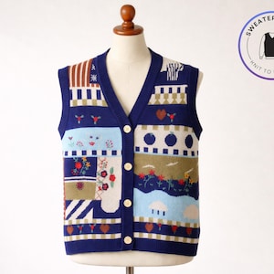 May include: A navy blue sweater vest with a V-neck and button closure. The vest features a patchwork design with various patterns, including floral, geometric, and landscape motifs. The text "SWEATER & VEST - KNIT TO IMPRESS" is in a circular graphic.