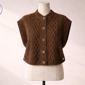 May include: A brown cable-knit vest with a button-up front. The vest has a high neckline and short sleeves. The vest is displayed on a mannequin. The image includes a logo that says "Sweater & Vest" and "Suit to Impress".