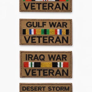 May include: Four tan fabric patches with embroidered text and ribbon designs. The patches read "AFGHANISTAN VETERAN", "GULF WAR VETERAN", "IRAQ WAR VETERAN", and "DESERT STORM VETERAN". Each patch has a different ribbon design.