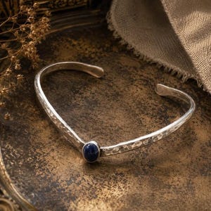 Brazalete vintage artesanal de plata esterlina martillada con diseño de espiga y ónix negro.