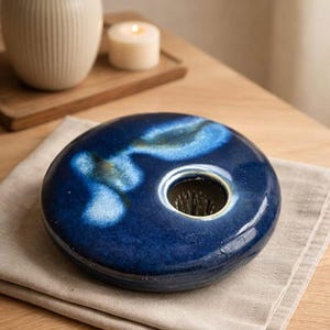 Peut inclure: Une tasse en céramique blanche avec une anse noire et le texte "But First, Coffee" en gras noir. La tasse est posée sur un fond neutre, soulignant son design simple.