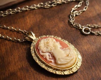 Collar con colgante de camafeo de imitación en tono dorado vintage, perfil clásico.