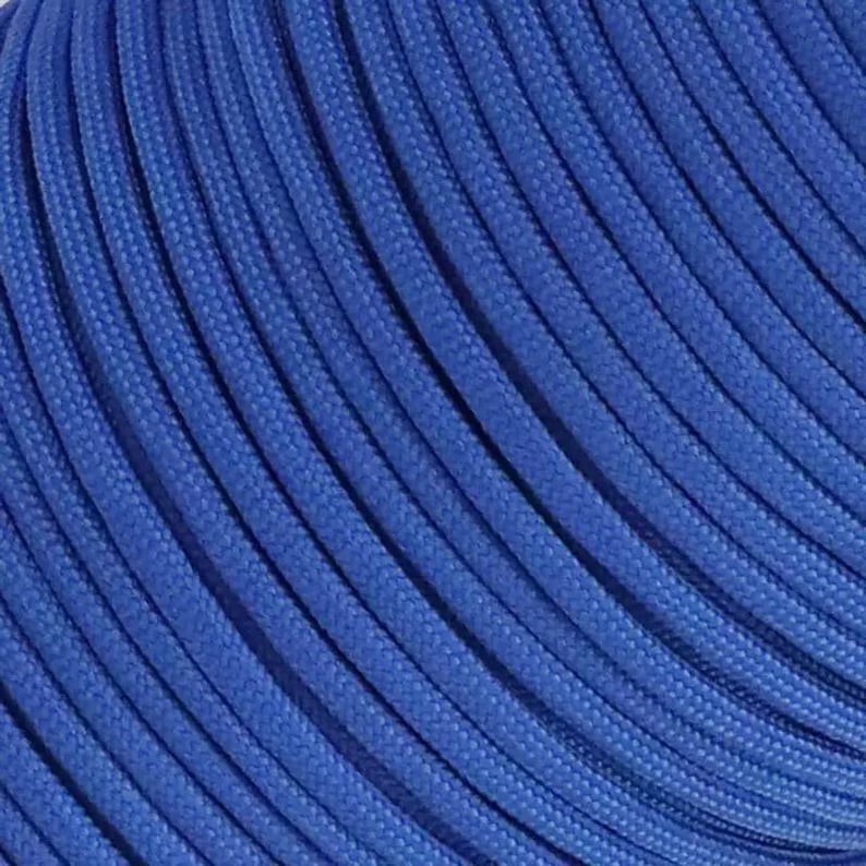 May include: A vibrant royal blue cord featuring a tightly woven, multi-strand construction. The surface of the cord displays a consistent, textured pattern of diagonal lines created by the braided fibers, showing a uniform color throughout the length.