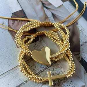Conjunto de pulsera de cuentas doradas con dijes de corazón y cruz, joyería apilable de cobre.