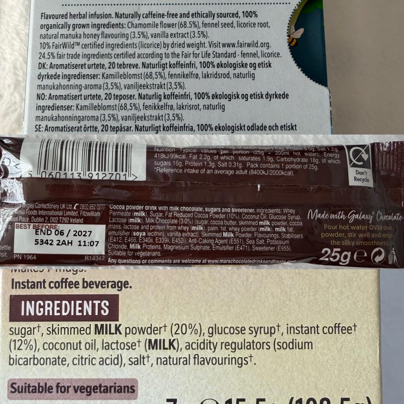 May include: A package of Galaxy Chocolate cocoa powder drink with ingredients listed, including sugar, milk powder, and coconut oil. The package also features text about the product's nutritional information and a 'Best Before' date.