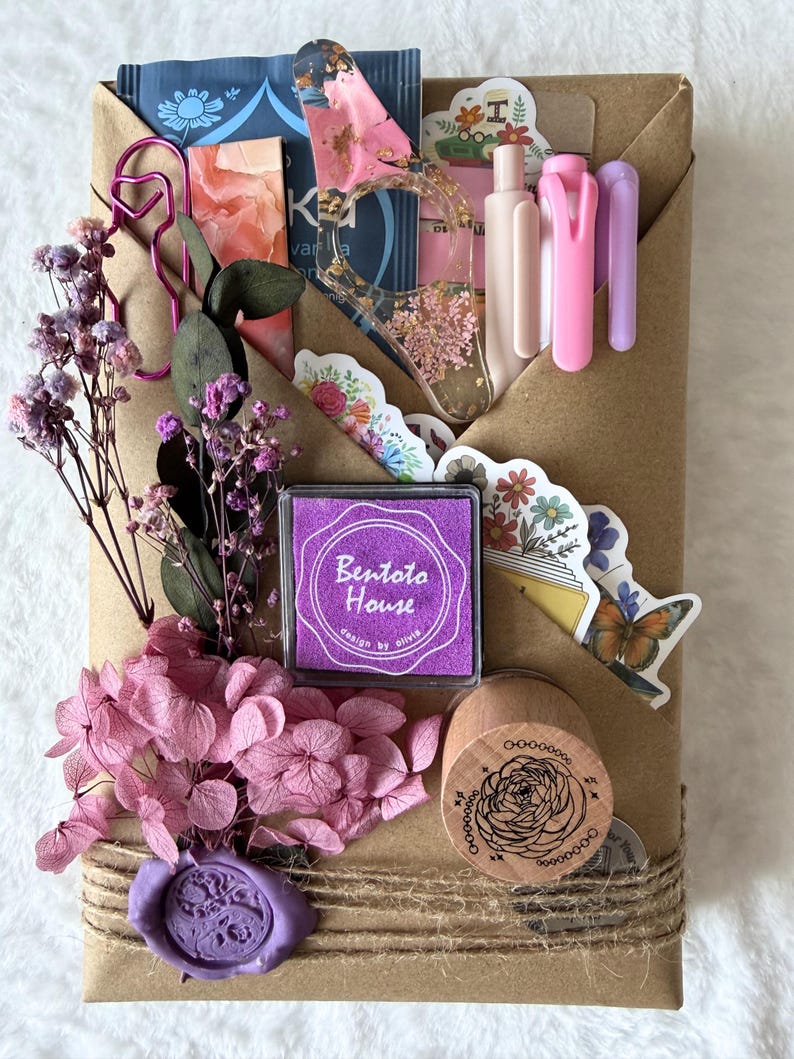 May include: A brown paper package tied with twine, adorned with dried flowers, stickers, and stationery. Includes a purple ink pad with the text "Bentoto House", a wooden stamp, and a purple wax seal.