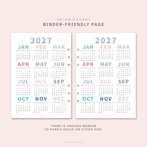 May include: Two white 2027 year-at-a-glance calendar pages with pastel-colored month headings. The text reads 2027 YEAR AT A GLANCE BINDER-FRIENDLY PAGE and THERE IS ENOUGH MARGIN TO PUNCH HOLES ON EITHER SIDE. One page features pre-punched holes.