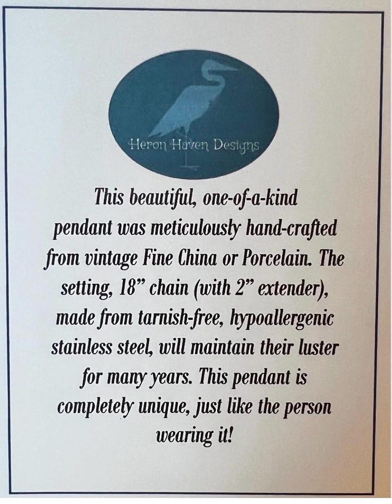 May include: A white card with text describing a handcrafted pendant from Heron Haven Designs. The pendant is made from vintage Fine China or Porcelain, with an 18-inch chain and a 2-inch extender.