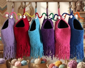Può includere: Sei sacchetti all'uncinetto appesi in viola, rosso, azzurro, viola scuro, rosa e blu scuro. Ogni sacchetto presenta un'ampia apertura, due occhi mobili bianchi e due antenne colorate in scovolino. La base è dotata di lunghe frange.