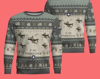 Può includere: Una maglia grigia a maniche lunghe e girocollo con un motivo ripetuto di aerei da combattimento F-4C Phantom II, bandiere americane, piastrine di riconoscimento e renne. Il testo F-4C PHANTOM II è stampato con un emblema a stella.