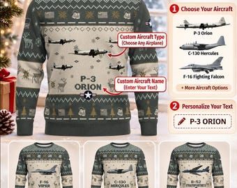 Può includere: Un maglione a maniche lunghe con girocollo grigio scuro caratterizzato da un motivo ripetuto di renne, alberi di pino e bandiere americane. Il centro mostra illustrazioni di aerei e il testo P-3 ORION con un emblema a stella. Il design include opzioni personalizzabili.