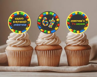 Puede incluir: Tres cupcakes con glaseado blanco, cada uno coronado con una decoración circular. Las decoraciones presentan diseños de bloques coloridos y mensajes de cumpleaños: "Happy Birthday Jonathan", "I was 67, now I'm 7" y "Jonathan's 7th Birthday".