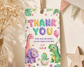 Puede incluir: Una etiqueta de regalo rectangular con cuerda de yute, con ilustraciones en acuarela de dinosaurios, hojas tropicales y flores. El texto dice: THANK YOU. STOMP. ROAR. AND THANKS A TON FOR COMING TO MY PARTY! LOVE. LILA.